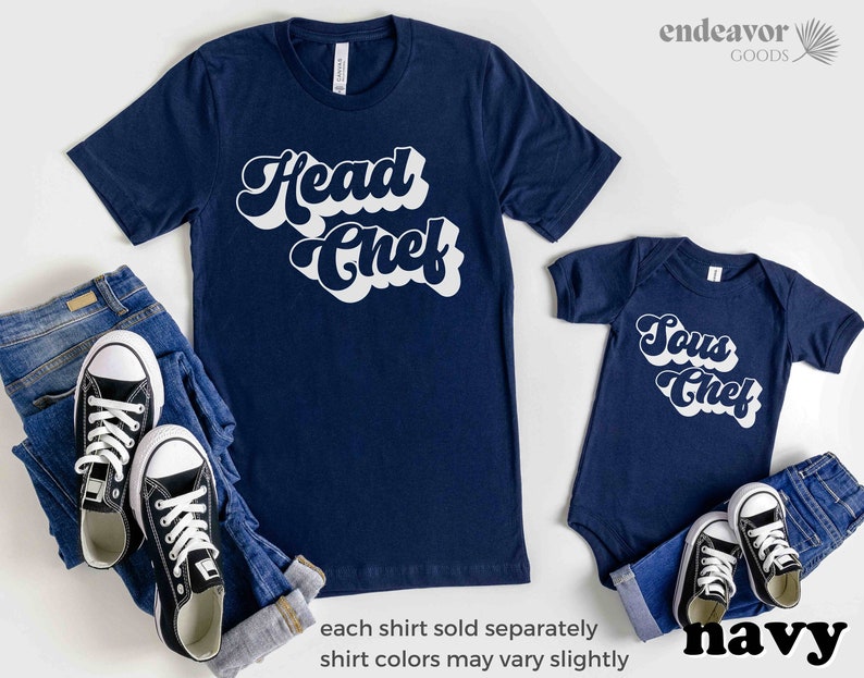 K&ouml;nnte beinhalten: Zwei marineblaue T-Shirts mit wei&szlig;em Retro-Text. Das gr&ouml;&szlig;ere Shirt sagt "Chefkoch" und das kleinere Shirt sagt "Sous Chef".