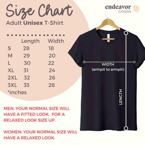 以下が含まれることがあります： ハンガーに掛けられた黒い大人用ユニセックスTシャツ。サイズチャートがあり、Sから3XLまでのサイズが表示され、長さと幅の測定値はインチです。テキストはフィット感についてアドバイスしています。測定値はインチで、例えば長さは71cmです。