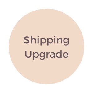 May include: A beige circle with the text "Shipping Upgrade" in dark gray.