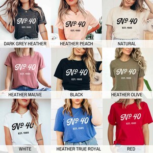 May include: A selection of t-shirts in various colors, each featuring a white graphic with the text "No. 40 Est. 1985". The colors include dark grey heather, heather peach, natural, heather mauve, black, heather olive, white, heather true royal, and red.