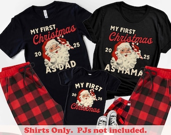 Puede incluir: Camisetas navideñas negras y azul marino con un gráfico de Papá Noel y el texto "My First Christmas" y "As Dad" o "As Mama". También se ven pantalones de pijama a cuadros rojos y negros. También se incluye un body para bebé.