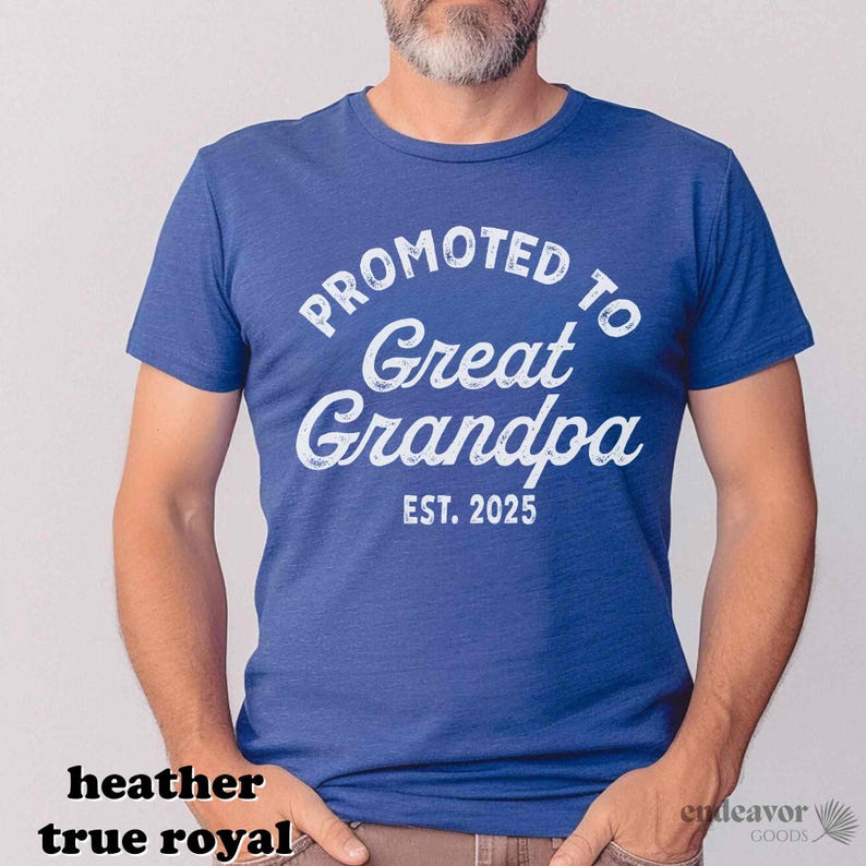 May include: A heather true royal blue t-shirt with the text "PROMOTED TO Great Grandpa EST. 2025" in white script. The shirt is a crew neck style and is made of a soft material.