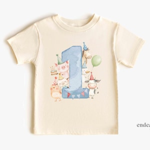 May include: Cream-colored toddler t-shirt featuring a large blue number "1" with a watercolor design. The number is surrounded by cartoon farm animals wearing party hats and holding balloons, celebrating a first birthday.