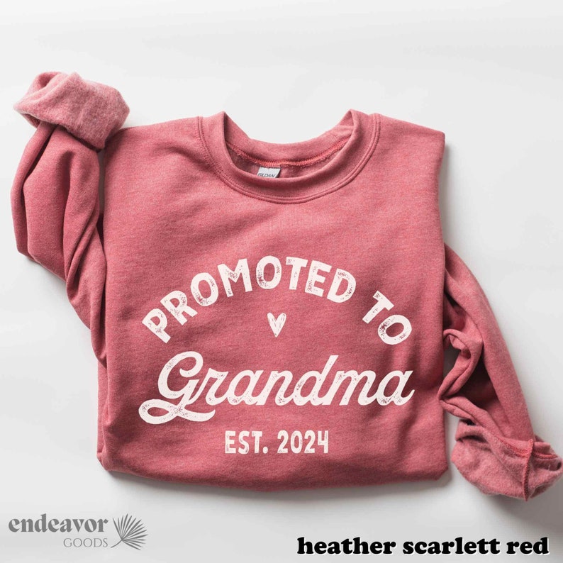 May include: A heather scarlet red sweatshirt with the text "Promoted to Grandma Est. 2024" in white.
