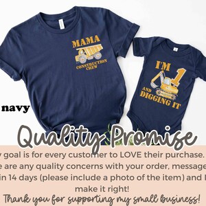 May include: Navy blue t-shirt with "MAMA CONSTRUCTION CREW" graphic and a matching baby bodysuit with "I'M AND DIGGING IT" graphic. Both garments feature construction vehicle illustrations in yellow and gold.