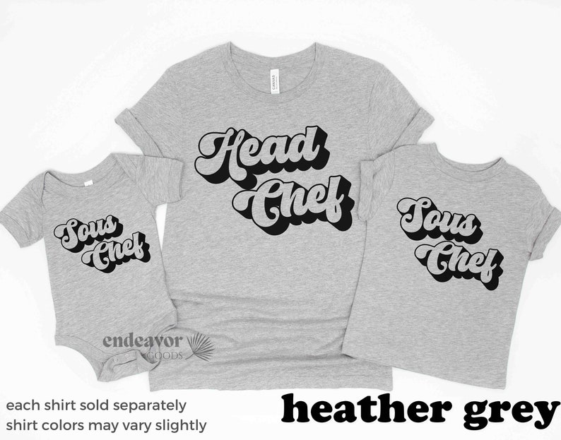 K&ouml;nnte beinhalten: Drei T-Shirts in Heather Grey mit Retro-Schriftzug. Das gr&ouml;&szlig;te T-Shirt sagt "Head Chef", das mittlere T-Shirt sagt "Sous Chef" und das kleinste T-Shirt sagt "Sous Chef".