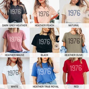 May include: A selection of t-shirts in diverse colours, each displaying the year "1976" in a prominent, outlined font. Colours include dark grey heather, heather peach, natural, heather mauve, black, heather olive, white, heather true royal, and red.