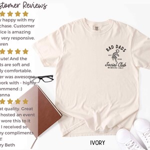May include: Ivory t-shirt with a black graphic of a tiger with the text "Rad Dads Social Club Members Only" on the front. Customer reviews are shown on the left side of the image.