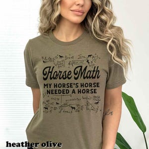 Może przedstawiać: Heather oliwkowa koszulka z napisem "Horse Math" oraz r&oacute;wnaniami matematycznymi i ilustracjami koni. Koszulka głosi r&oacute;wnież "My horse's horse needed a horse".