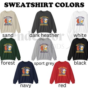 May include: A set of ten sweatshirts in various colors, each featuring a graphic of a cartoon sausage and beer mug with the text "On My Wurst Behavior". The colors include sand, dark heather, white, forest, sport grey, black, navy, and red.