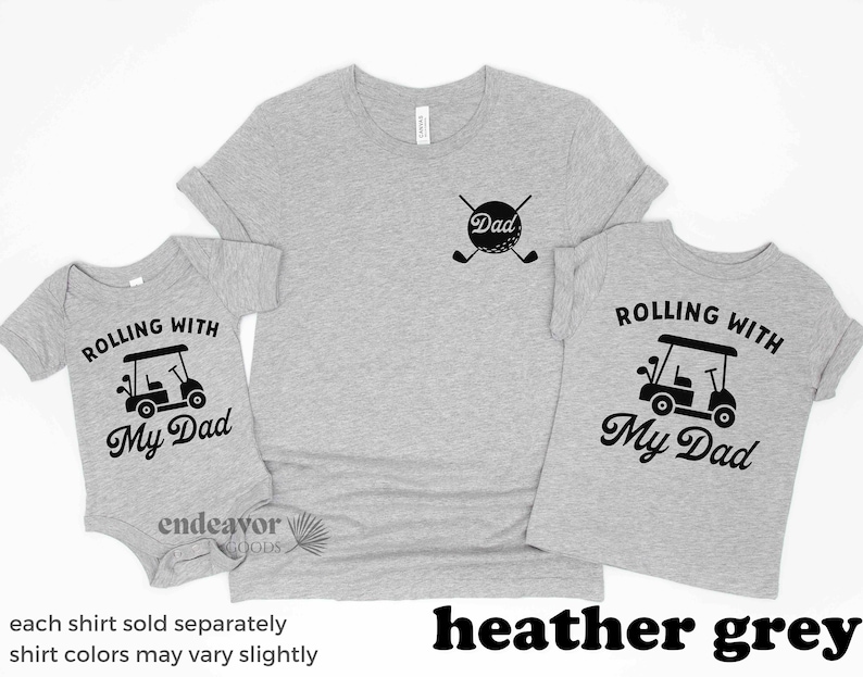 May include: Three heather grey t-shirts with a golf cart and the text "Rolling with My Dad". The adult shirt has the text "Dad" and a golf ball with crossed golf clubs.