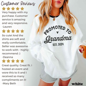 May include: White sweatshirt with black text that reads "Promoted to Grandma Est. 2024". A woman is wearing the sweatshirt and holding a mug.