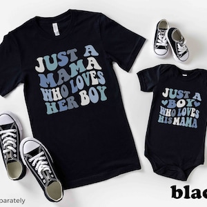 May include: Black t-shirt with the text "Just a Mama Who Loves Her Boy" in blue and white lettering. A matching black bodysuit with the text "Just a Boy Who Loves His Mama" in blue and white lettering.