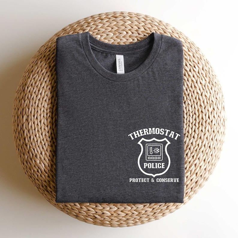 May include: A dark gray t-shirt with a white graphic of a thermostat with the text "Thermostat Police Protect & Conserve".