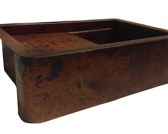 May include: A rectangular copper kitchen sink with a hammered finish. The sink has a small drainboard on one side.