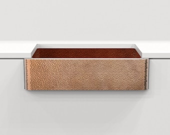 May include: A hammered copper farmhouse sink with a stainless steel rim. The sink is installed in a white countertop.