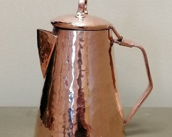 May include: A hammered copper teapot with a lid and a handle. The teapot has a rounded body and a spout.