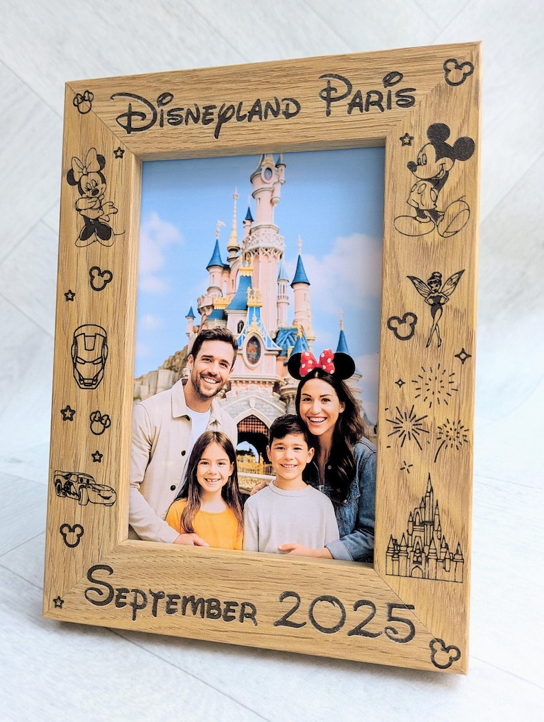 May include: Wooden photo frame with the text "Disneyland Paris" and "September 2025". The frame features etched Disney character designs and a family photo in front of a castle.