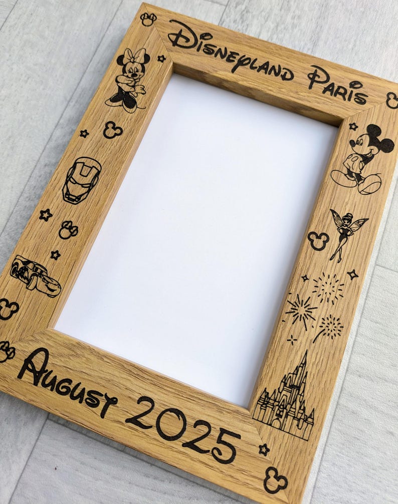 May include: Wooden picture frame with the words "Disneyland Paris" and "August 2025" etched into the wood. The frame is decorated with Disney character illustrations, including Mickey and Minnie Mouse, and other Disney-themed icons.