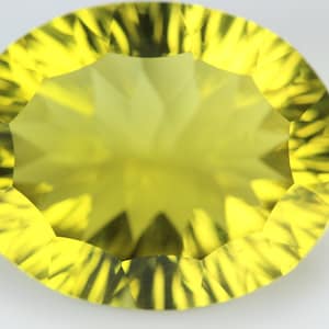 Puede incluir: Una gema facetada de color amarillo brillante con un patrón de estrella en el centro.
