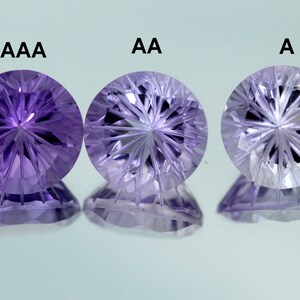 May include: Three amethyst gemstones of varying quality, labeled AAA, AA, and A. The gemstones are round and have a star-shaped pattern inside.