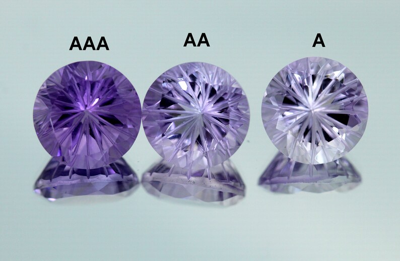 May include: Three amethyst gemstones of varying quality, labeled AAA, AA, and A. The gemstones are round and have a star-shaped pattern inside.