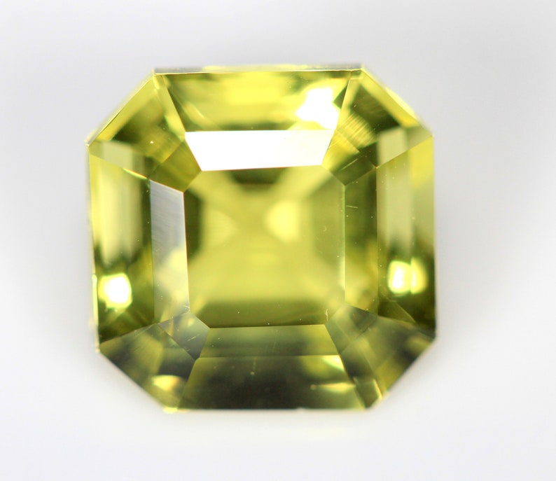 May include: A light green gemstone with a square emerald cut.