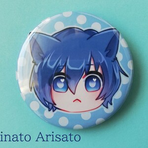 May include: A blue and white button featuring a cartoon character with blue hair and cat ears. The character is set against a light blue background with white polka dots. The text "Minato Arisato" is below the button.
