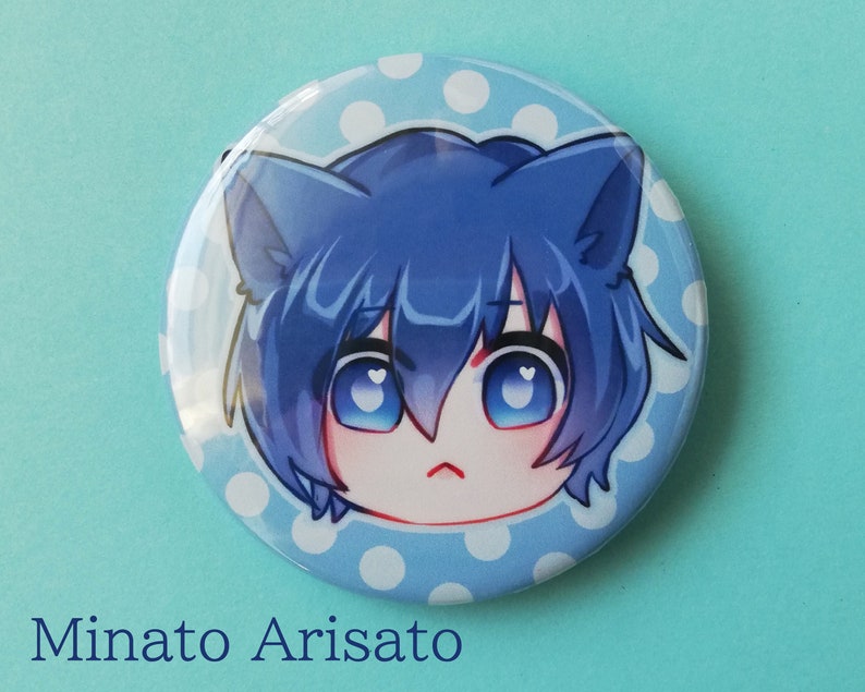 May include: A blue and white button featuring a cartoon character with blue hair and cat ears. The character is set against a light blue background with white polka dots. The text "Minato Arisato" is below the button.