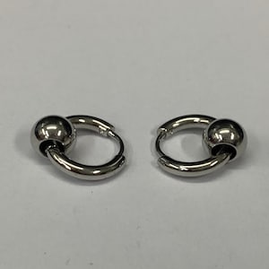 May include: A pair of silver hoop earrings with a ball at the end of each hoop.