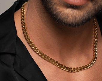 以下が含まれることがあります： カーブリンクスタイルのゴールドチェーンネックレス。チェーンは黒いシャツを着た人が着用しています。