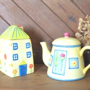 Peut inclure: Une théière en céramique jaune avec un motif floral bleu et blanc et un sucrier assorti en forme de maison en céramique jaune avec un toit vert.
