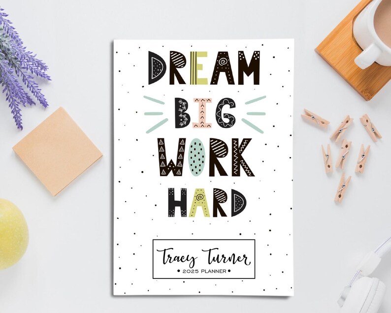 May include: A white planner with black polka dots and the text "DREAM BIG WORK HARD" in colorful, stylized lettering. The planner is personalized with the name "Tracey Turner" and the year "2023".