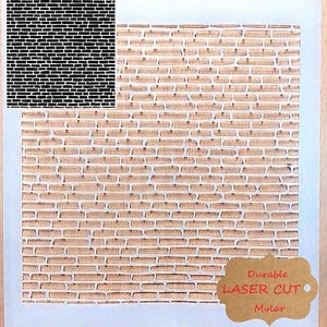 May include: A brick wall design stencil. The stencil shows a brick pattern cut out. The words "Durable LASER CUT Mylar" are printed on a brown tag. The stencil is rectangular in shape.