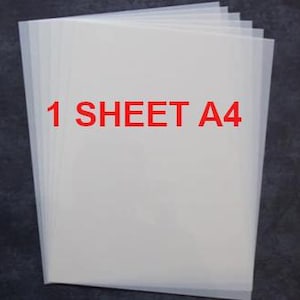 May include: A stack of translucent white A4 sheets of paper against a dark background. The text "1 SHEET A4" is printed in red across the top of the paper. The paper appears to be new and unused.
