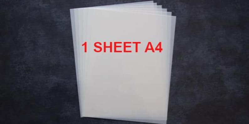 May include: A stack of translucent white A4 sheets of paper against a dark background. The text "1 SHEET A4" is printed in red across the top of the paper. The paper appears to be new and unused.