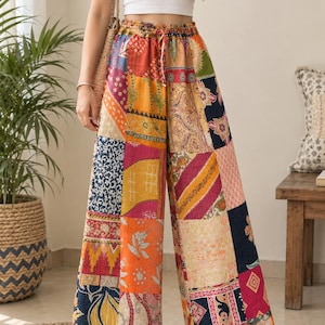 May include: Wide-leg trousers featuring a patchwork design with various colourful fabric patterns including floral, geometric, and paisley motifs in shades of orange, yellow, pink, blue, and cream, with an elasticated drawstring waistband.