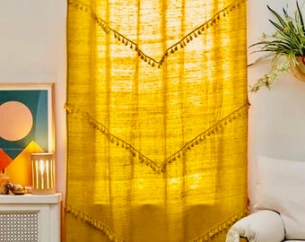 May include: A pair of mustard yellow curtains with a fringe trim. The curtains are hung on a rod and have a scalloped top.