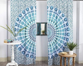 May include: A pair of blue and white mandala patterned curtains hang in a window. The curtains are made of a thin, lightweight fabric and have a bohemian style.