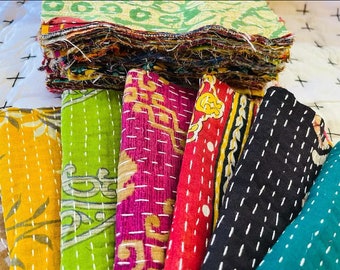 May include: A stack of colorful kantha quilts with various patterns and stitching. The quilts are made from recycled saris and are a traditional Indian craft.