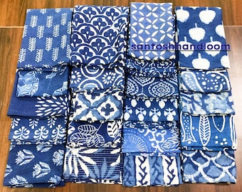 May include: A collection of 24 indigo blue cotton napkins with various white block printed patterns. The napkins are folded and stacked in rows. The text "santoshhandloom" is visible in the center of the image.