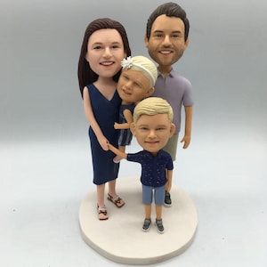 Op de afbeelding: Een gezin van vier op maat gemaakte figuren. De figuren zijn realistisch geschilderd en staan in een staande positie. Het gezin bestaat uit een man, een vrouw, een meisje en een jongen. De figuren dragen allemaal casual kleding. De figuren staan op een witte basis.