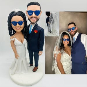 Hochzeitspaar Bobblehead, Braut gekleidet in einem weißen Brautkleid ， Bräutigam trägt einen dunkelblauen Anzug, beide tragen blaue Sonnenbrillen