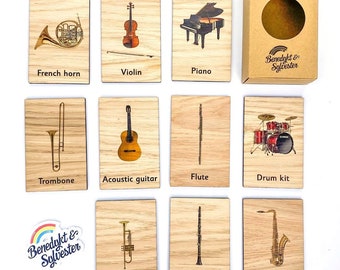 May include: Set of 10 wooden Montessori learning tiles featuring images of musical instruments, including a French horn, violin, piano, trombone, acoustic guitar, flute, drum kit, trumpet, clarinet, and saxophone. The tiles are labeled with the name of each instrument.
