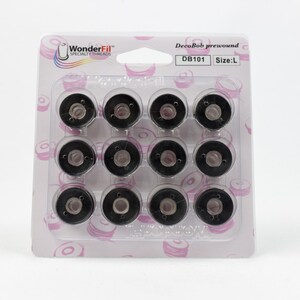 May include: A package of 12 black DecoBob prewound bobbins, size L, for sewing machines. The bobbins are in a clear plastic package with a pink and white background. The package has the text "DecoBob prewound" and "DB101 Size: L" on it.