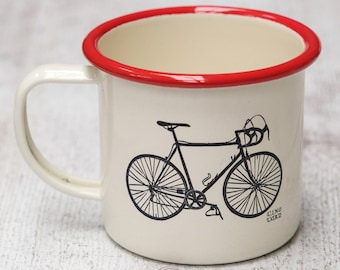May include: White enamel mug with a red rim featuring a black and white illustration of a bicycle with the text "LINO LORO" on the bottom.
