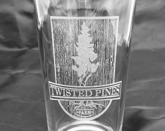 May include: A clear glass pint glass with an etched design of a pine tree and the words "Twisted Pines Farm"