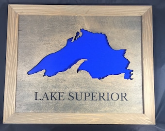 May include: A wooden sign with a blue cutout of Lake Superior and the text "LAKE SUPERIOR" below the cutout.