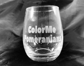 May include: A clear glass wine glass with the text "Color Me Pomeranians" etched on the side.