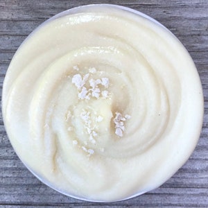 Könnte beinhalten: Eine weiße Schüssel gefüllt mit einer cremigen, weißen Substanz mit einem Wirbelmuster. Die Substanz ist mit kleinen, weißen Flocken bedeckt.